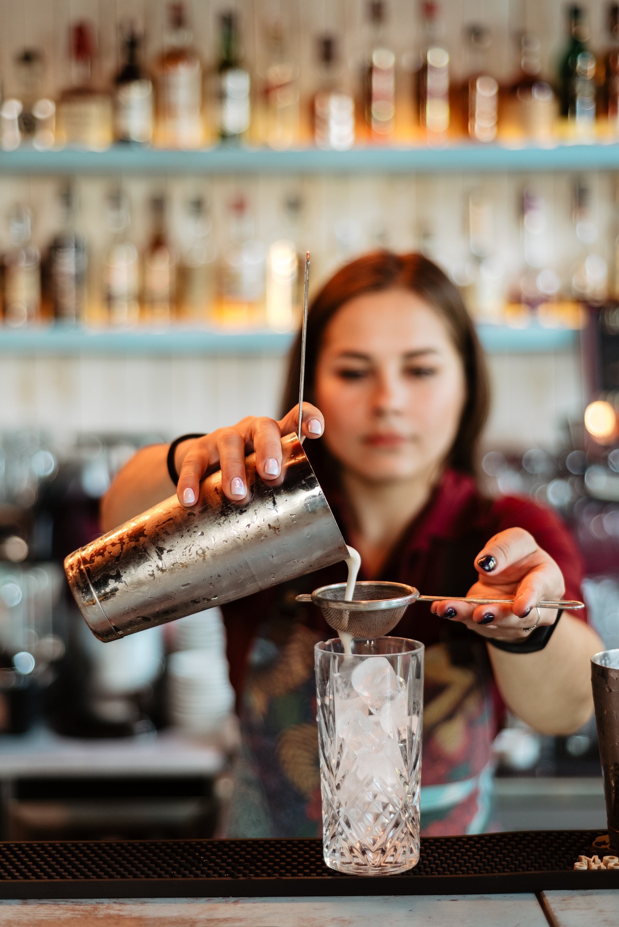 Barista making cocktail drinks in the bar